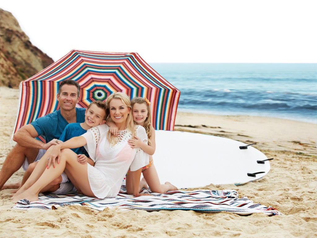 Family photoshoot in the beach with a pretty umbrella