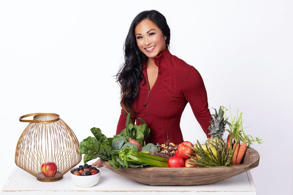 business woman standing in front of table with fruits and vegetables for orange county photoshoot